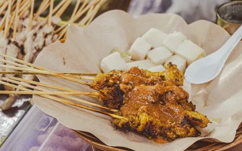 Grilled satay skewers with peanut sauce and rice cakes